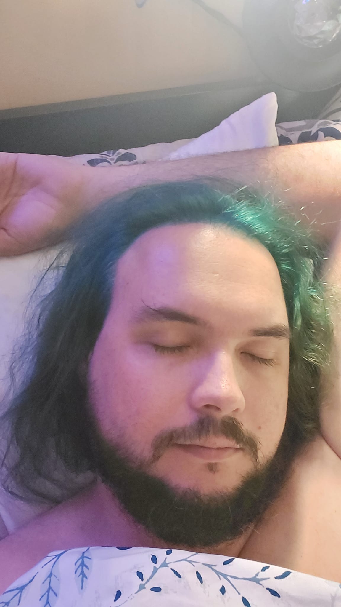 A man with green hair and a beard lays in bed, photo 3